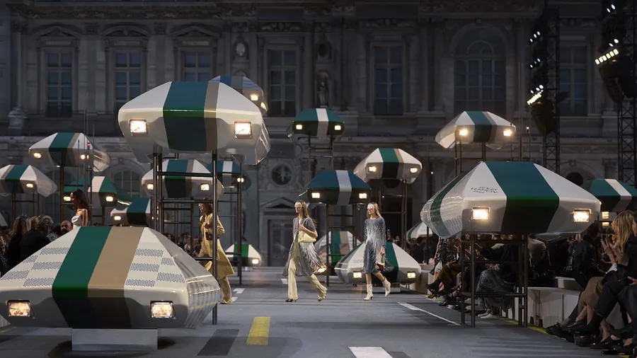 Louis Vuitton Spring-Summer 2027 show in the Cour Carrée of the Louvre: models walk between illuminated set pieces